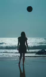 the woman in the dress is holding a balloon above her head