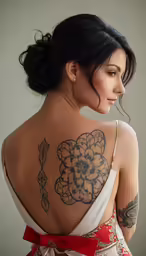 a woman has a tattoo on her back