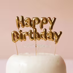 a white cake with gold happy birthday letters and the words happy birthday on it