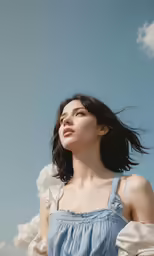 the young woman is standing and looking up