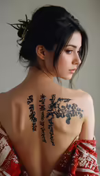 a girl with a japanese writing tattoo on her back
