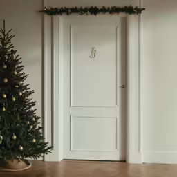 a white door with green garland around the entrance