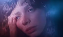 a woman that is holding her hands to her face