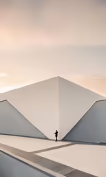 a lone man walking down the sidewalk towards an interesting structure