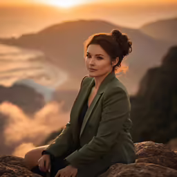 a lady that is sitting down with some kind of mountain view
