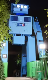 a blue robot statue sitting inside of a gate