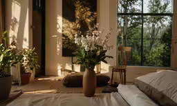 an empty bed room with white sheets and flowers