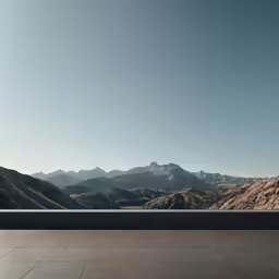an empty bench is sitting next to mountains