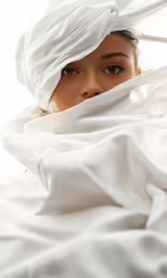 the woman has her hair flying over the white blanket