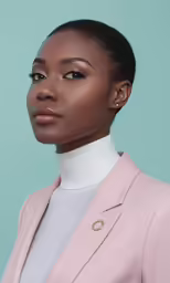 a black woman with a pink suit, pink tie and silver choker