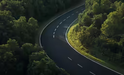 a very tall winding road through some trees