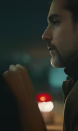 a man with a beard looks at the back of a car