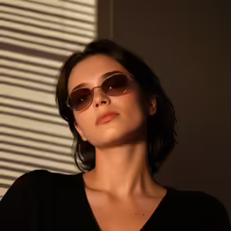 woman with dark glasses looking out the window