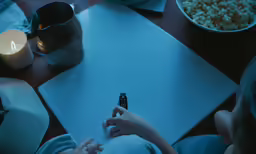 woman lying down on the ground with her hand on a remote control