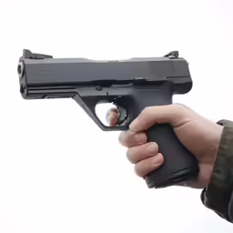 a person holding a gun with his right hand