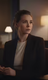 a beautiful woman sitting in a chair and looking into the camera