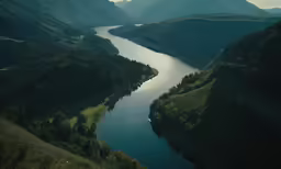 a river running through a lush green hillside