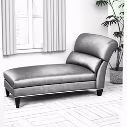 a grey chaise lounge chair in front of a white wall