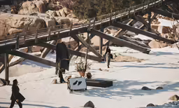 the people are walking up a hill in the snow