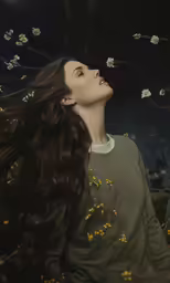 woman looking upward over head with her hair blowing