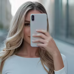 a woman is holding up a phone to take a selfie