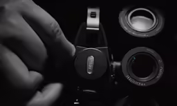 a man holding up two different lens parts to take photos