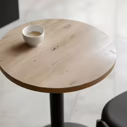 a cup of coffee on top of a wooden table