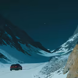 a long shot of some cars on a snowy road