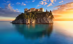 a castle sitting on top of a cliff on the water