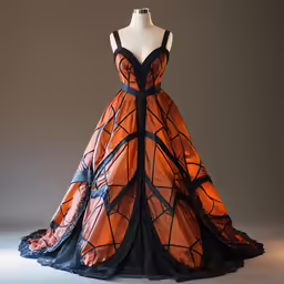 an orange dress on display on a white pedestal