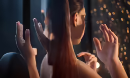 a woman with long red hair clapping while the other hand gestures