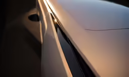 the sun shines through the reflection of a car window