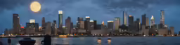 the view of city skyline at dusk from across the water
