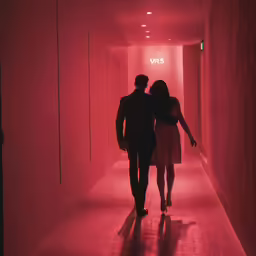 a man and woman are walking together in the dark