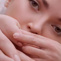 a close up shot of a person holding their hands in one hand