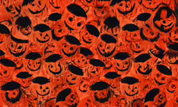 a background of faces painted in orange with black circles