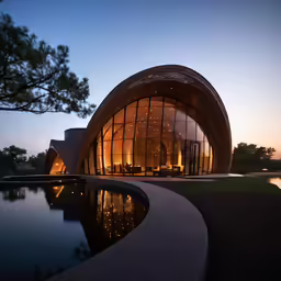 the circular building is lit up on both sides of the pool