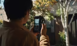 a boy holding up his cell phone to take a picture