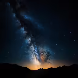 a large, bright light is shining on the top of a mountain under a dark night sky filled with stars