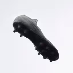 there is a black plastic thing hanging on a white background,a very large airplane kite is flying in the sky
