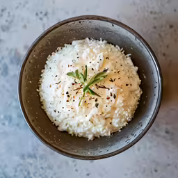 a bowl with rice and herbs in it
