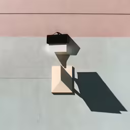 a square object casting a shadow in the concrete