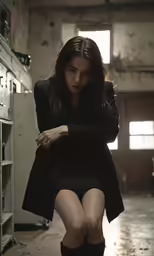 a woman sitting in a room with a drawer behind her