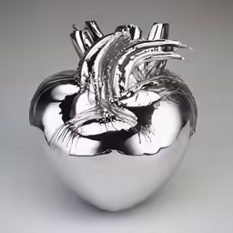 a silver heart sculpture sitting on a white surface