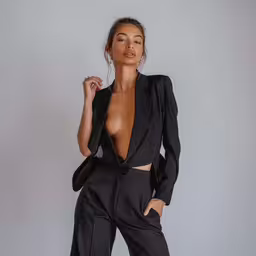 the model is posing in her black ensemble,the woman in black is posing with her shirt open