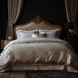 a bed with white pillows and blankets in a black bedroom