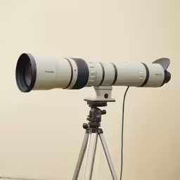 an optical lens on top of a tripod
