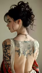 a woman with a tattoo on her back in a white dress