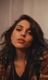 a woman with long hair looks up and sits