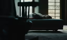 a girl is laying on the bed looking out the window